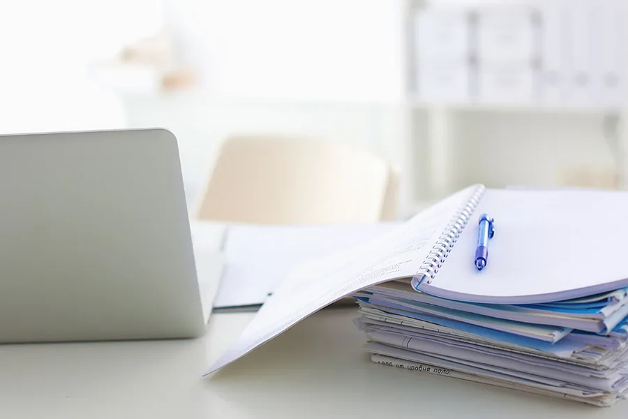 Bewertungsmethodik – Rechercheunterlagen und Notebook am Arbeitsplatz